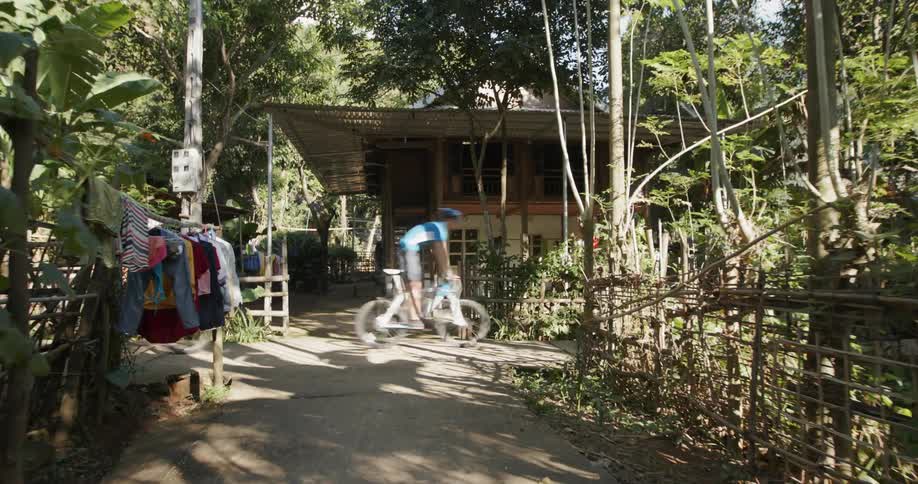 Bicyclists ride through a village