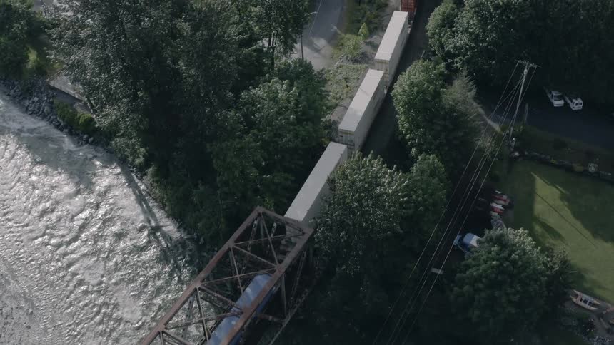 A train travels across the bridge - 4K Aerial