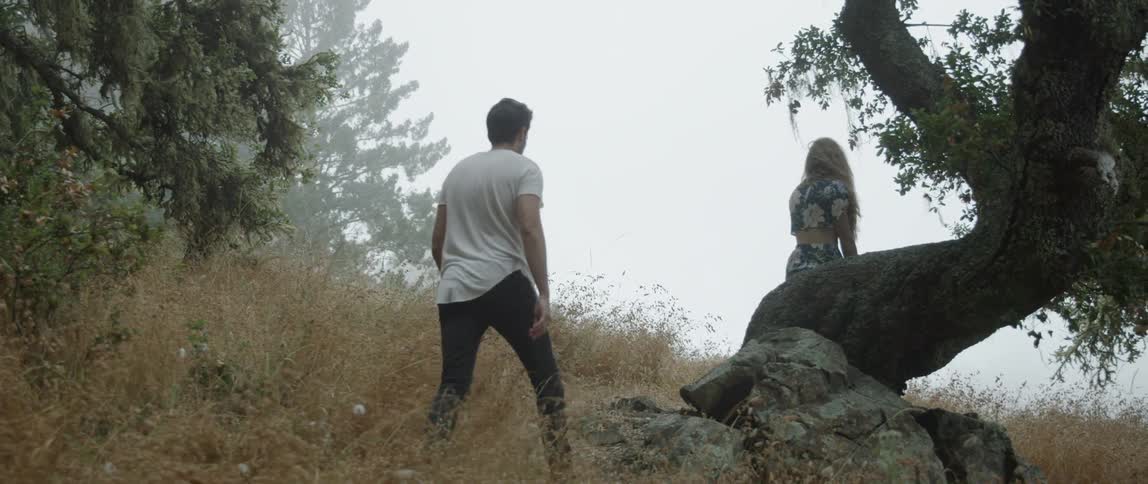 A man walks towards a woman on the hill
