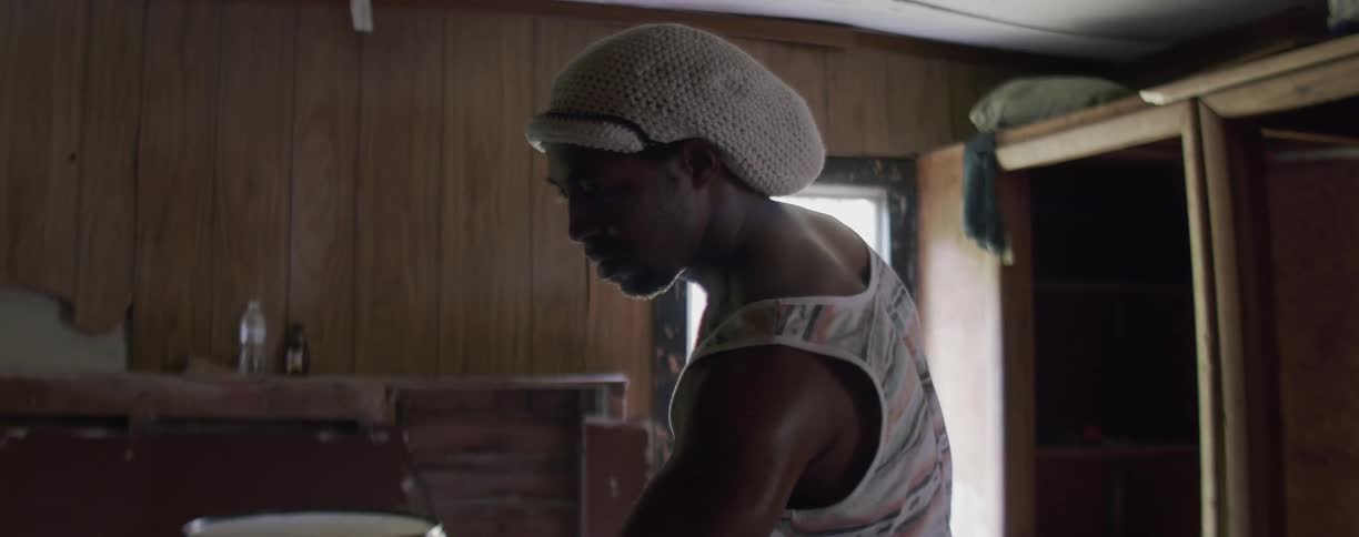 Man holds drumsticks as he approaches a set of drums