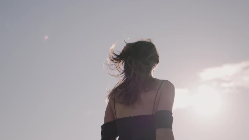 A woman walks on the field on a windy day
