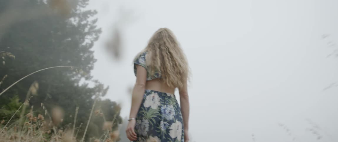 A woman walks through the grass