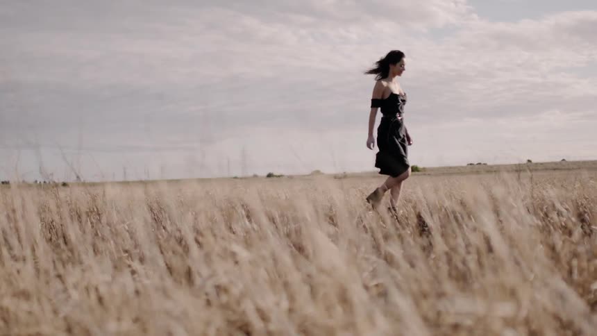 Woman walks in a rural grassy field