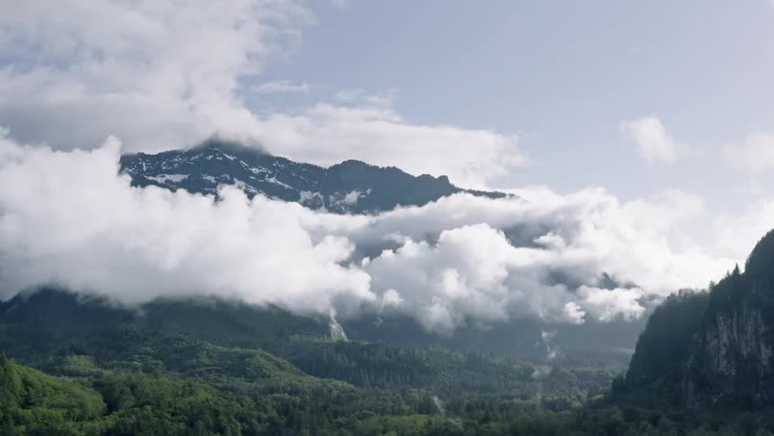Clouds sit around the mountain under a blue sky