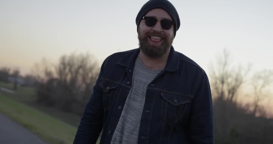 A man looks back smiling at sunset