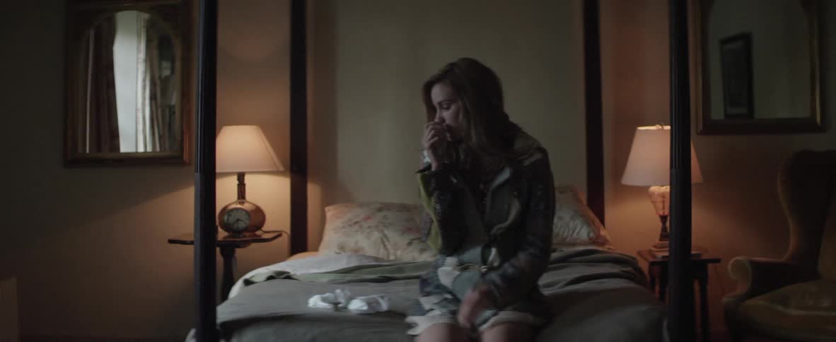 A woman sitting on a bed with tissues