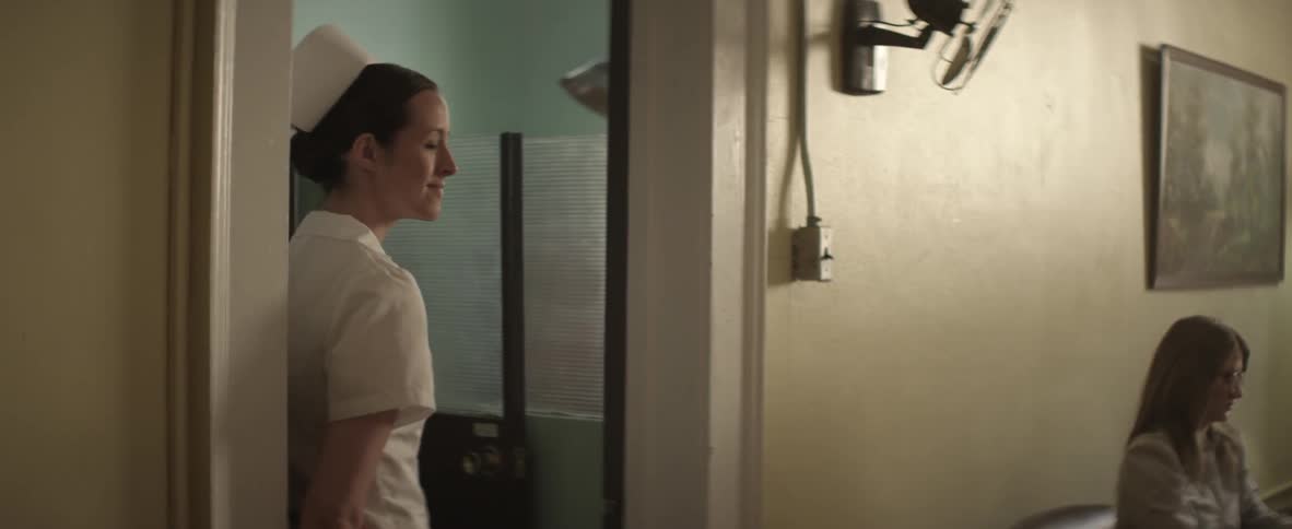 Nurse exits a door and calls in a patient