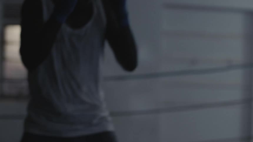 A boxer punches the air in a boxing ring