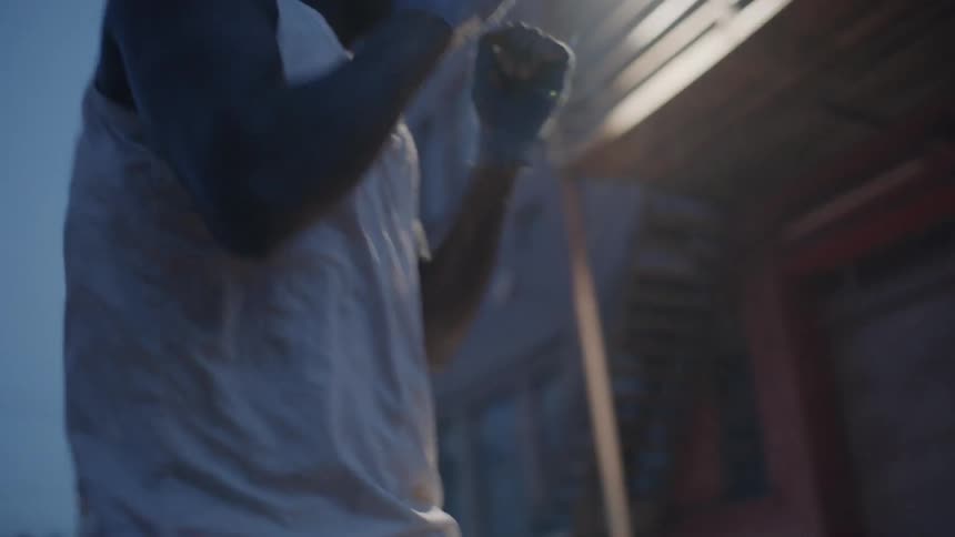 A man is shadowboxing in the lot