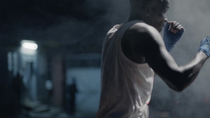 Man practices boxing outside at night