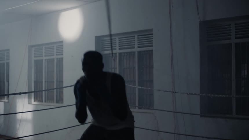 Man is doing boxing exercises in boxing ring