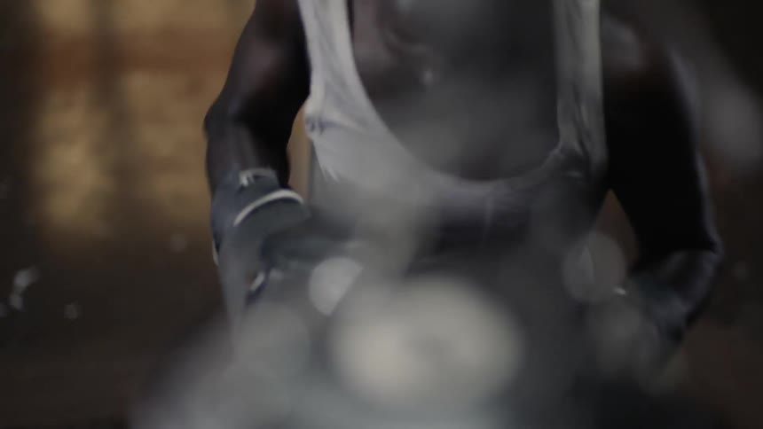 A man is punching the heavy bag in the gym