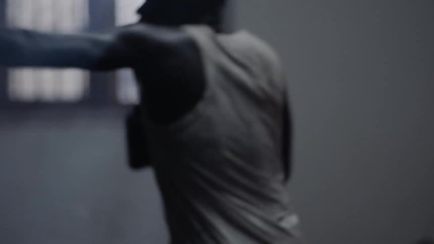 Man is boxing a punching bag in workout room