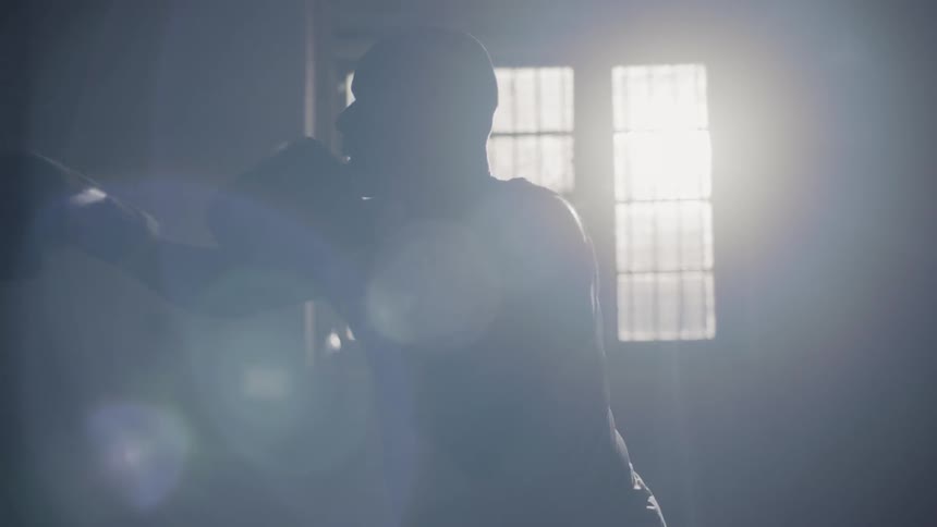 A man trains on a heavy punching bag