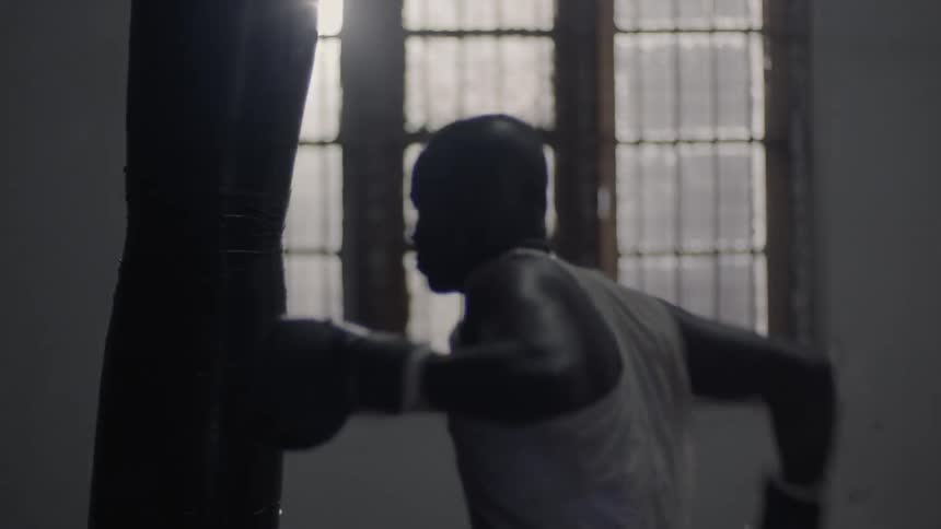 A man is punching the large heavy bag