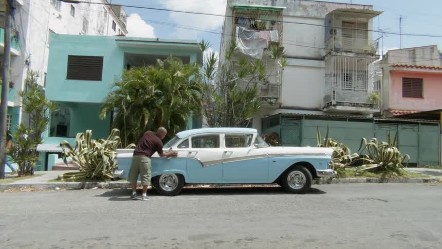 Man washing car on side of street