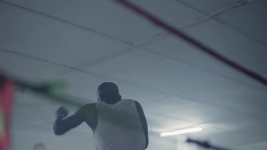 Man is practicing boxing in boxing ring