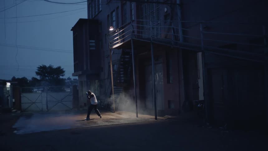 A man shadow boxes outside at night