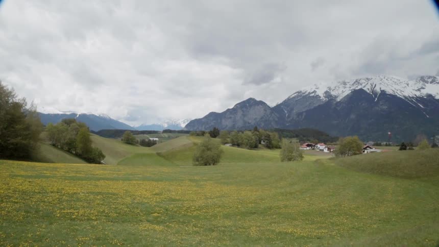 Clouds covering snowy mountains and meadows in the country