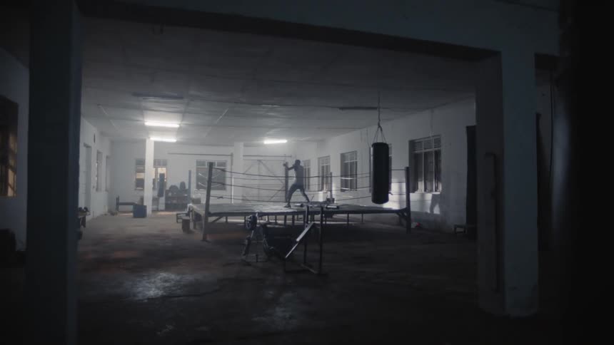 Man shadow boxes in a boxing gym