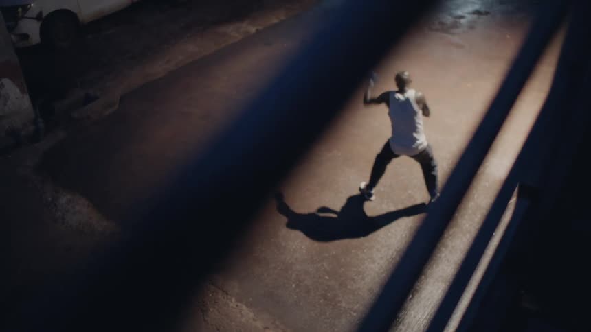 A man is shadow boxing outside at night