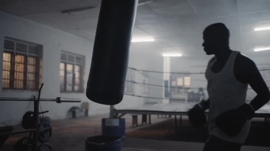 Man punches a punching bag in a gym