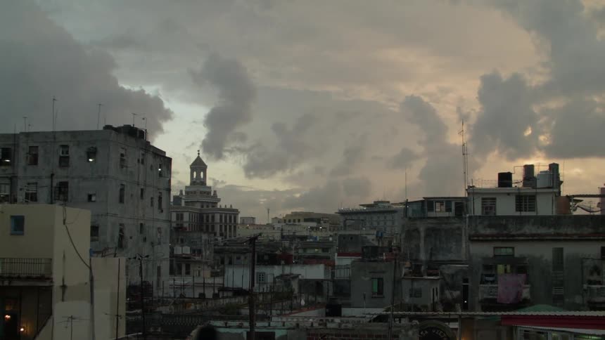 Clouds float above city buildings at sunset