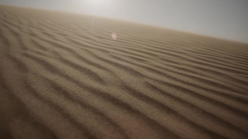 Wind blowing on sand dunes and creating ripples in the sand
