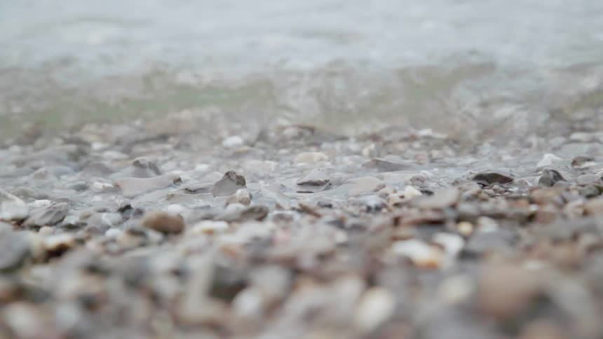 Lake waves wash over pebbles