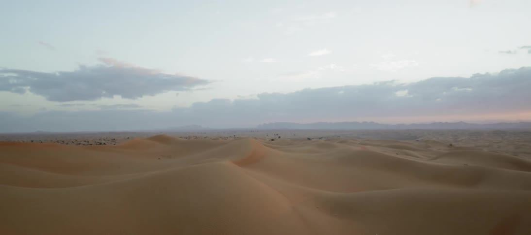 The sun sets over a desert landscape