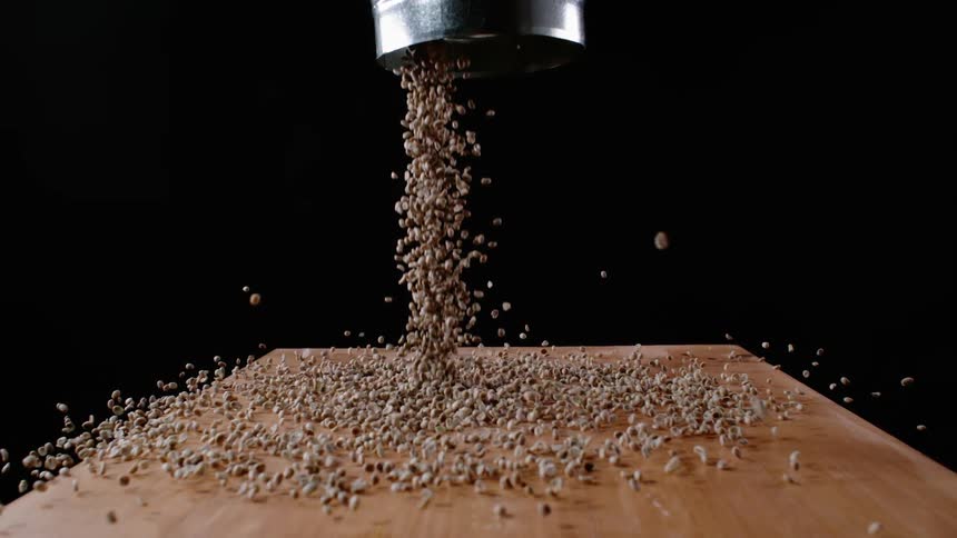 Coffee beans spill from canister on to table