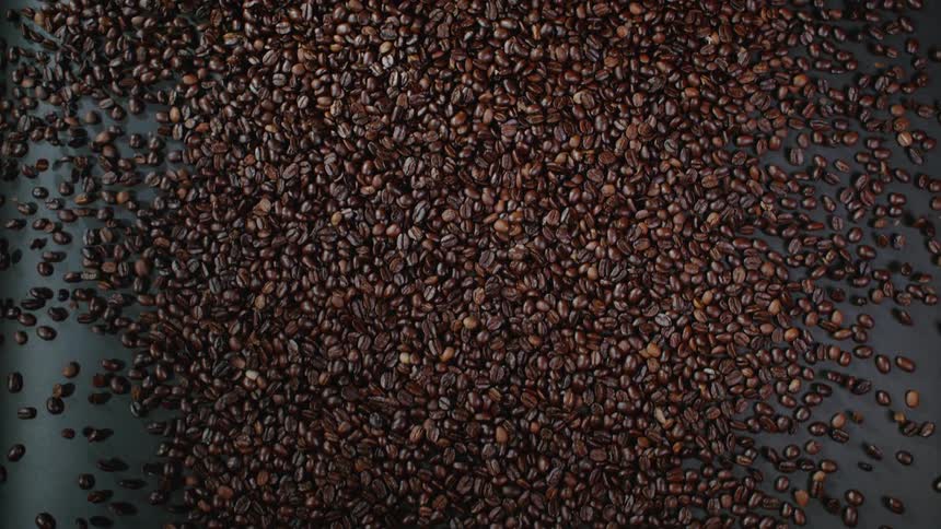 Coffee beans roll over the surface