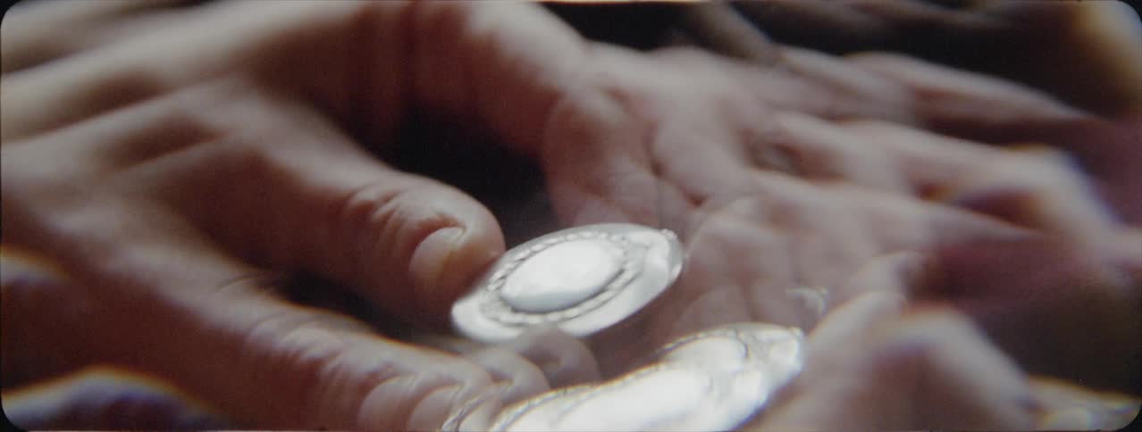 Person looks at a silver round amulet