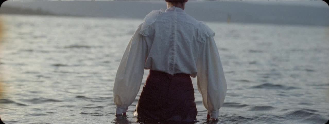 Fully clothed woman wades in a lake