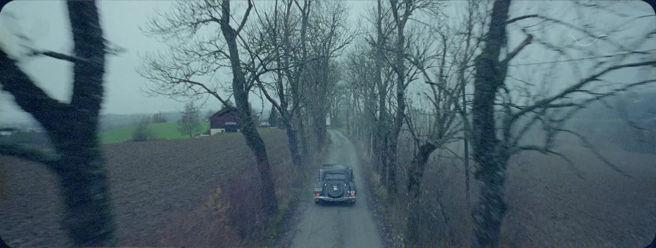 Old car is driving on foggy country road