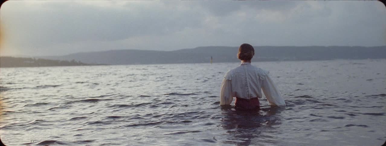 A fully clothed woman walks in a lake