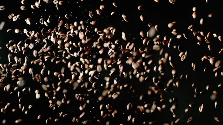 The coffee beans explode into the dark room
