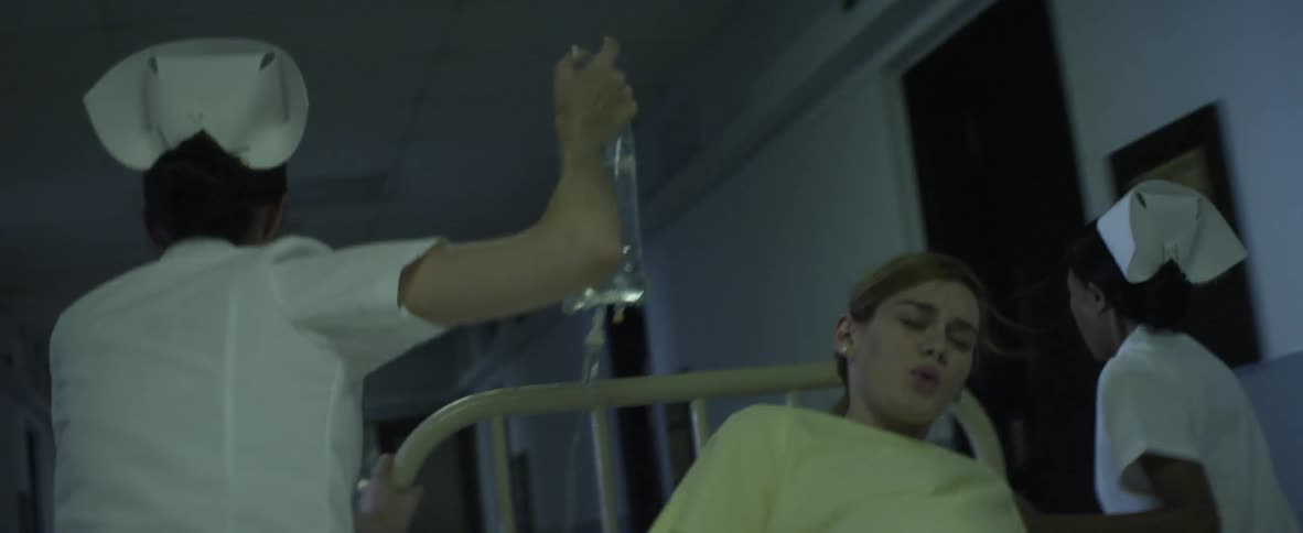 Pregnant woman being wheeled down a hall in bed