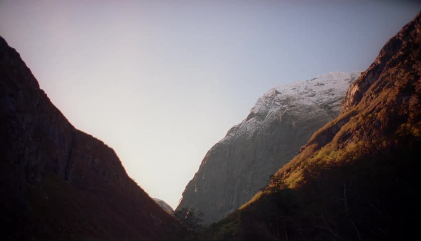 Dawn is breaking over a mountain valley in winter