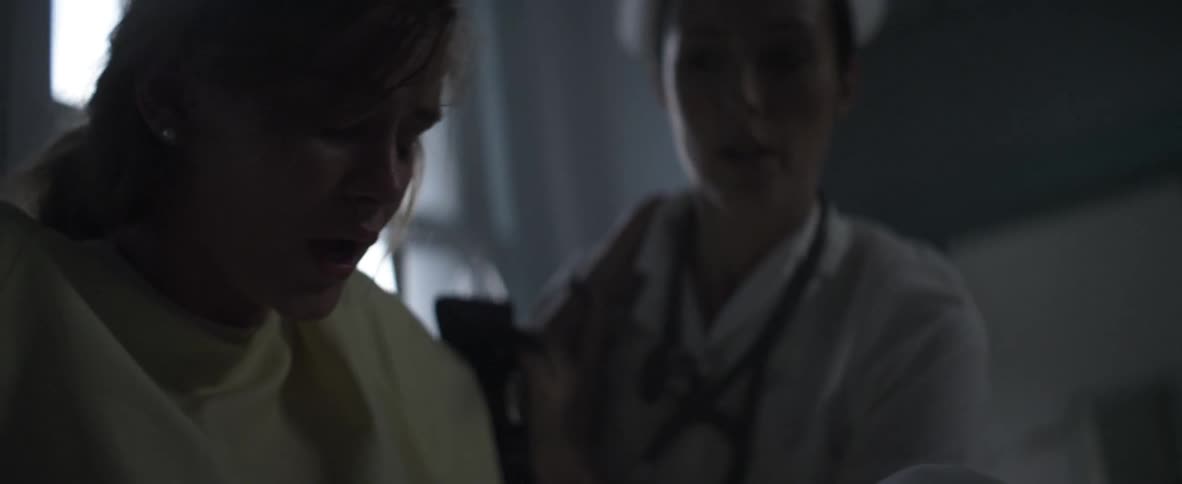 A nurse helps a woman who is experiencing labor pains