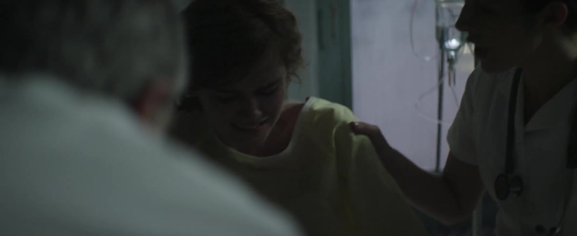 A doctor and a nurse assist a woman undergoing labor pains