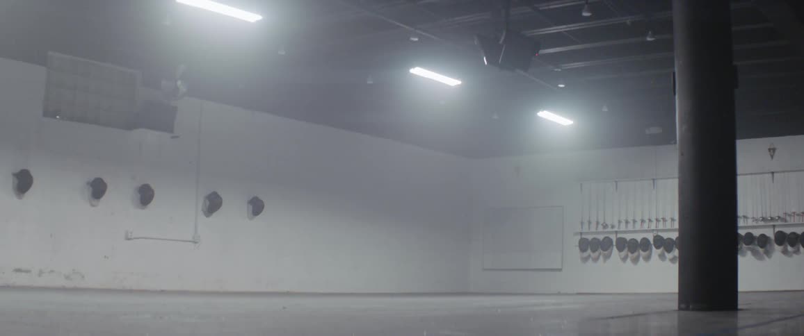 The room is foggy with fencing masks hanging on the wall