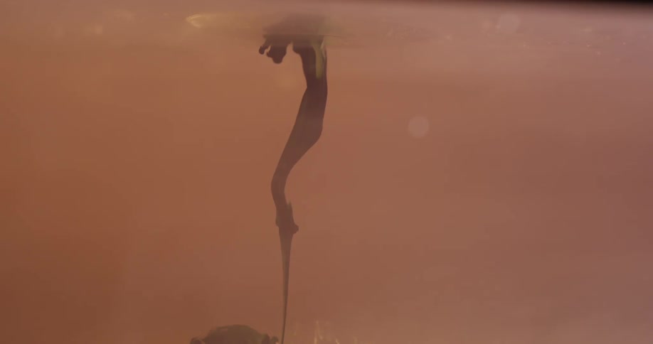 A solution drops into liquid, forming an upside down mushroom cloud