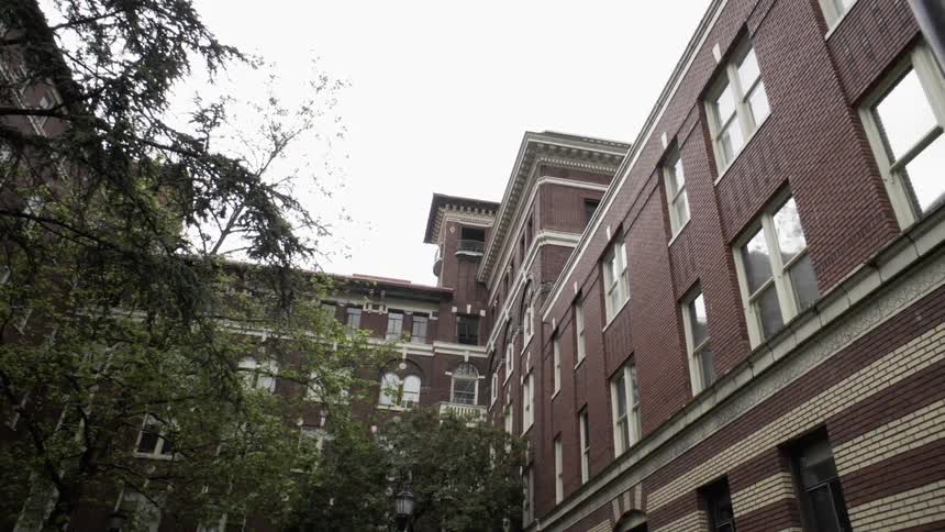 Large brown building with trees next to it