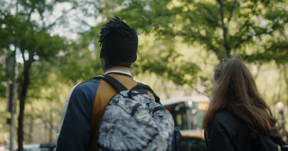 Man and woman walk past vehicles in a parking lot