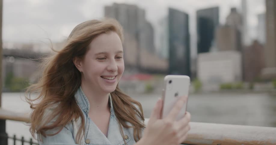 A woman smiles while looking at her phone