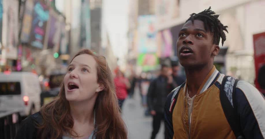 A man and woman laugh as they look around the city