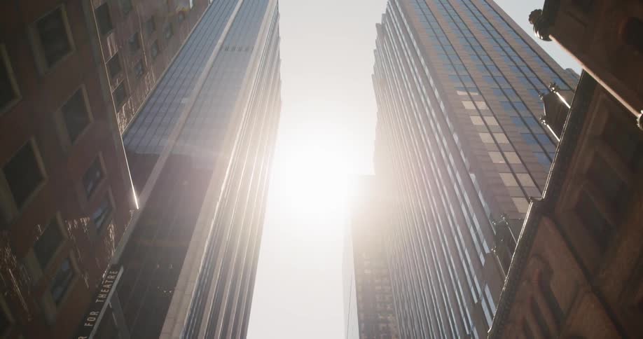 Sun shining between tall city buildings
