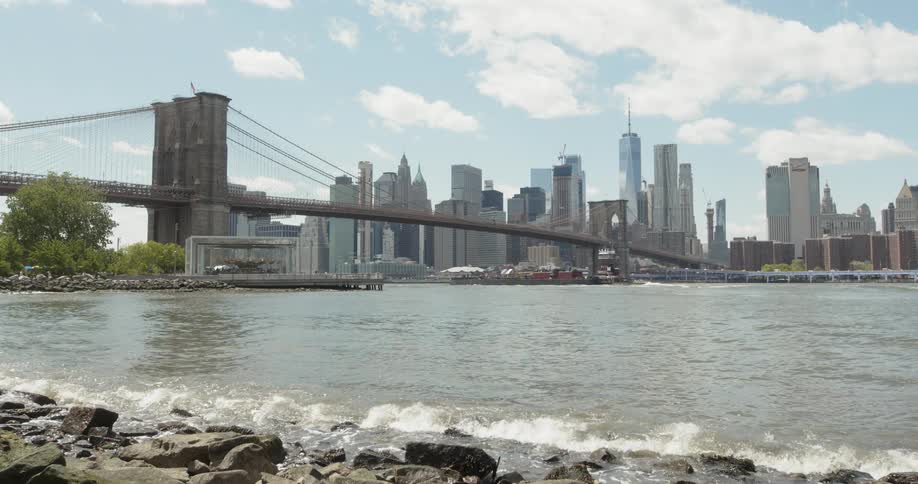 The water crashes against the shore by the city