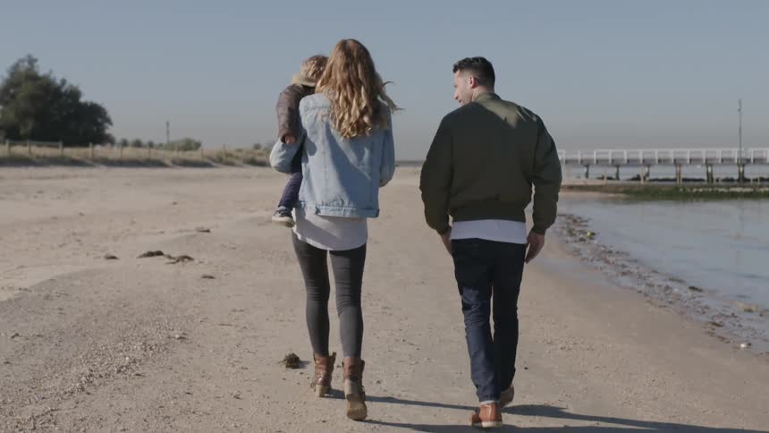 A family walk on the beach together